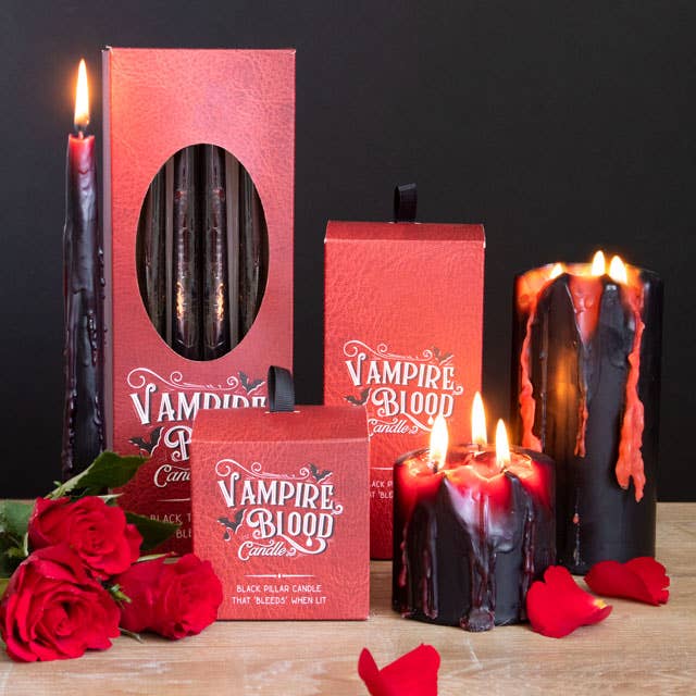 Vampire Blood candle collection lit with red roses and petals, black wax bleeding red for a vampire soiree