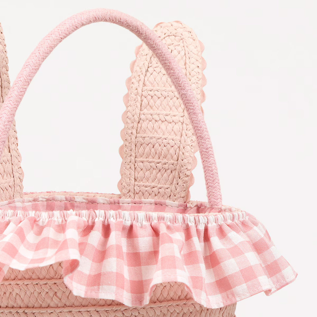 Close-up of the bunny Easter basket’s pink cord handle, raffia ears, and pink gingham ruffled lining.