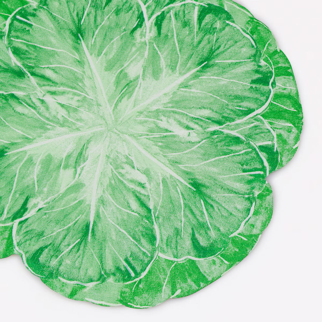 Close-up of a green 3-ply paper cocktail napkin shaped and printed like a cabbage leaf.