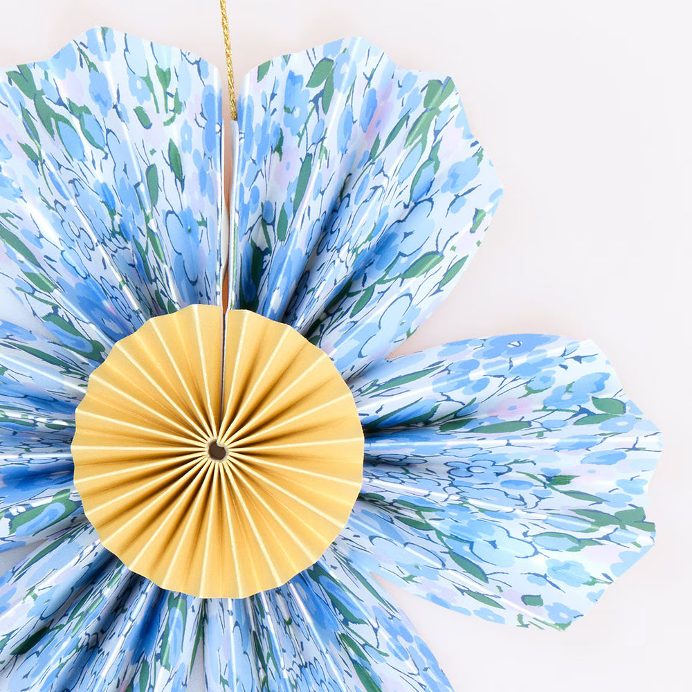 Close-up of a blue Liberty floral paper flower from the mini Easter decoration set, with a yellow pleated center.