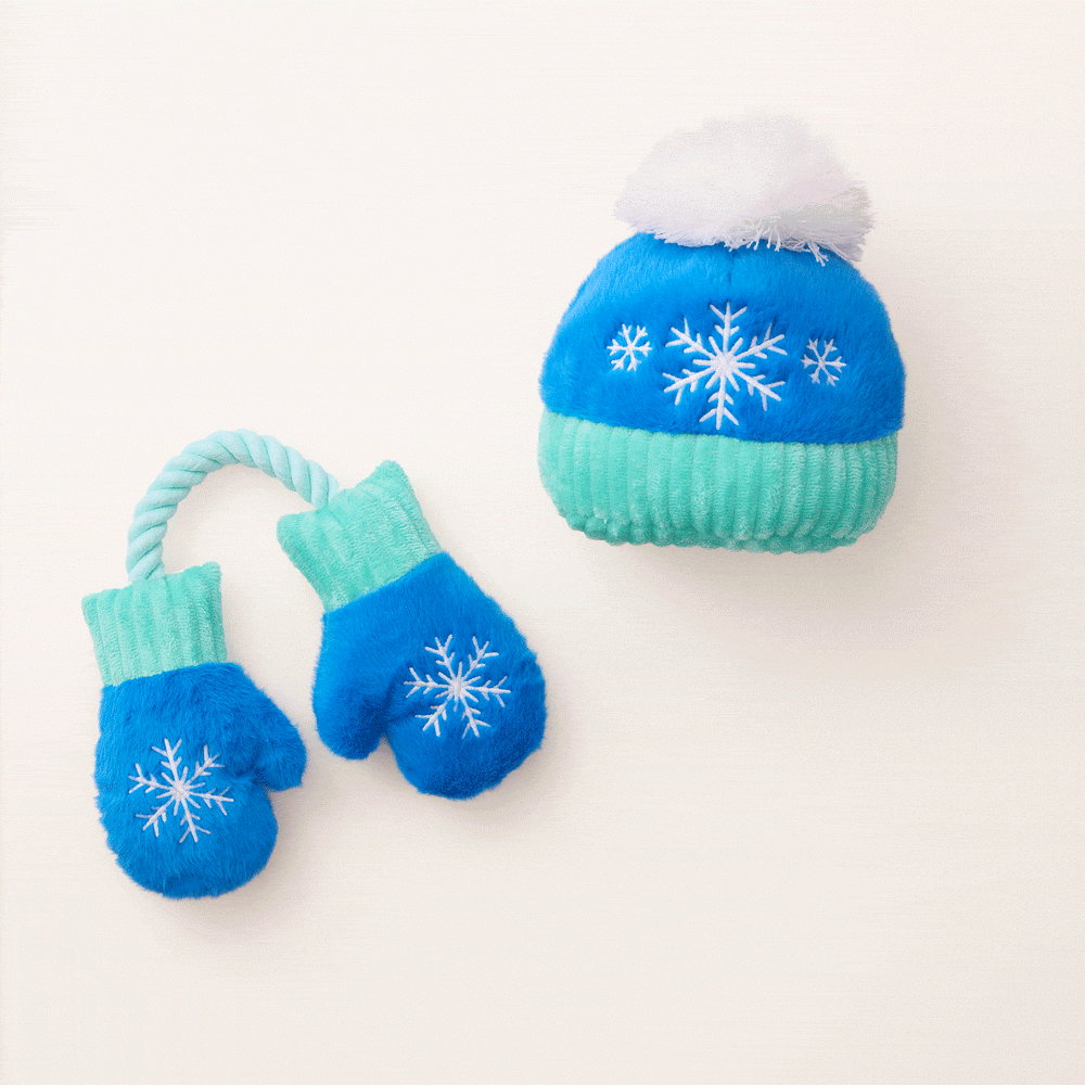 Animated clip of the snowflake hat and mittens dog toys on a cream backdrop