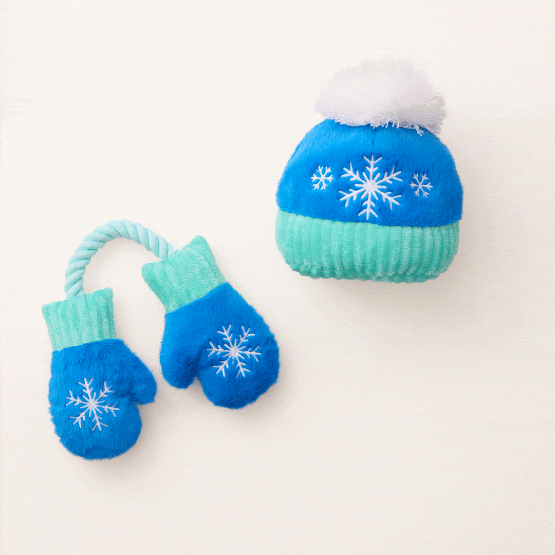 Animated clip of the snowflake hat and mittens dog toys on a cream backdrop