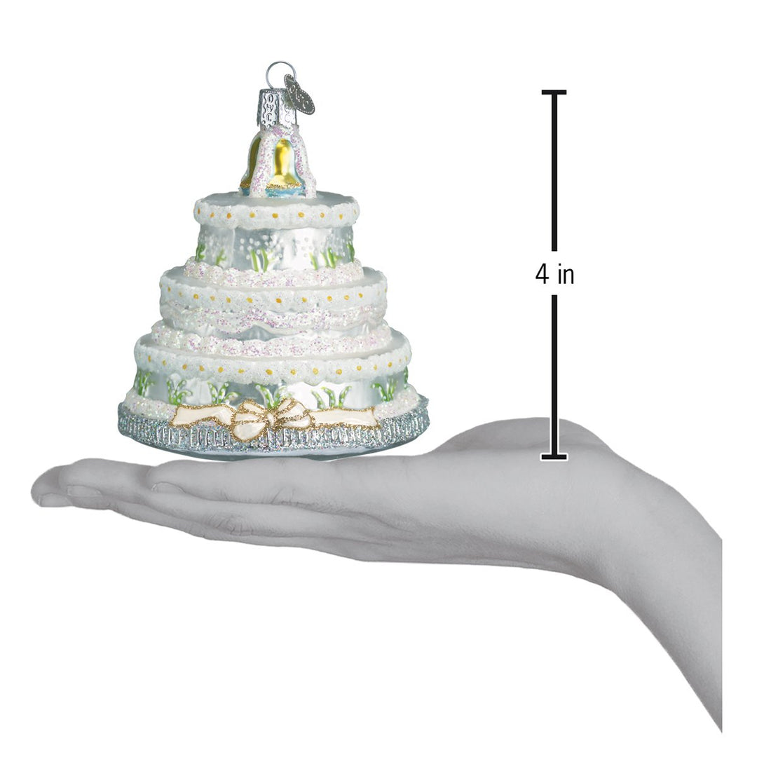 Wedding cake ornament on an open palm beside a 4 inch height marker