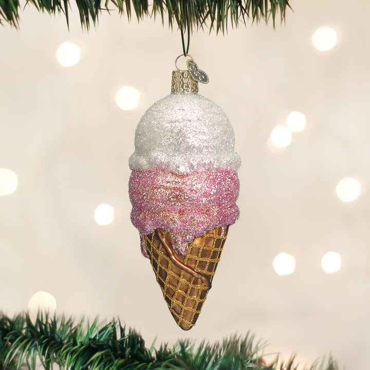 Ice cream cone glass ornament hanging on a lit Christmas tree