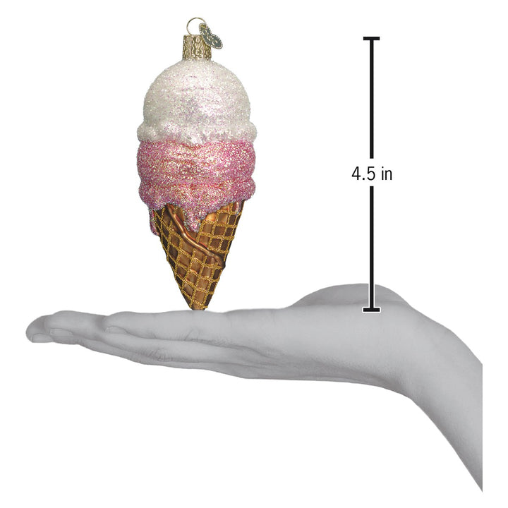 Ice cream cone ornament on an open palm beside a 4.5 inch height marker