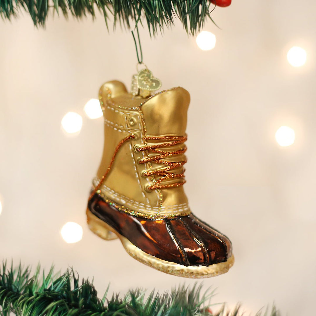 Field boot ornament hanging on a lit Christmas tree with soft bokeh lights