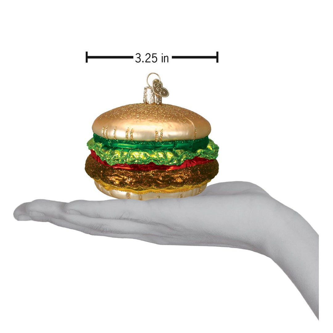 Cheeseburger ornament on an open palm under a 3.25 inch width marker for scale
