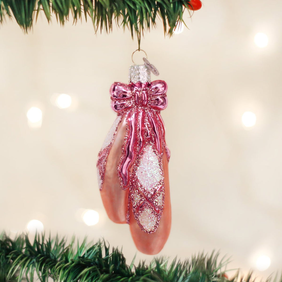 Ballet slippers ornament hanging on a Christmas tree with soft glowing lights, a gift for dancers
