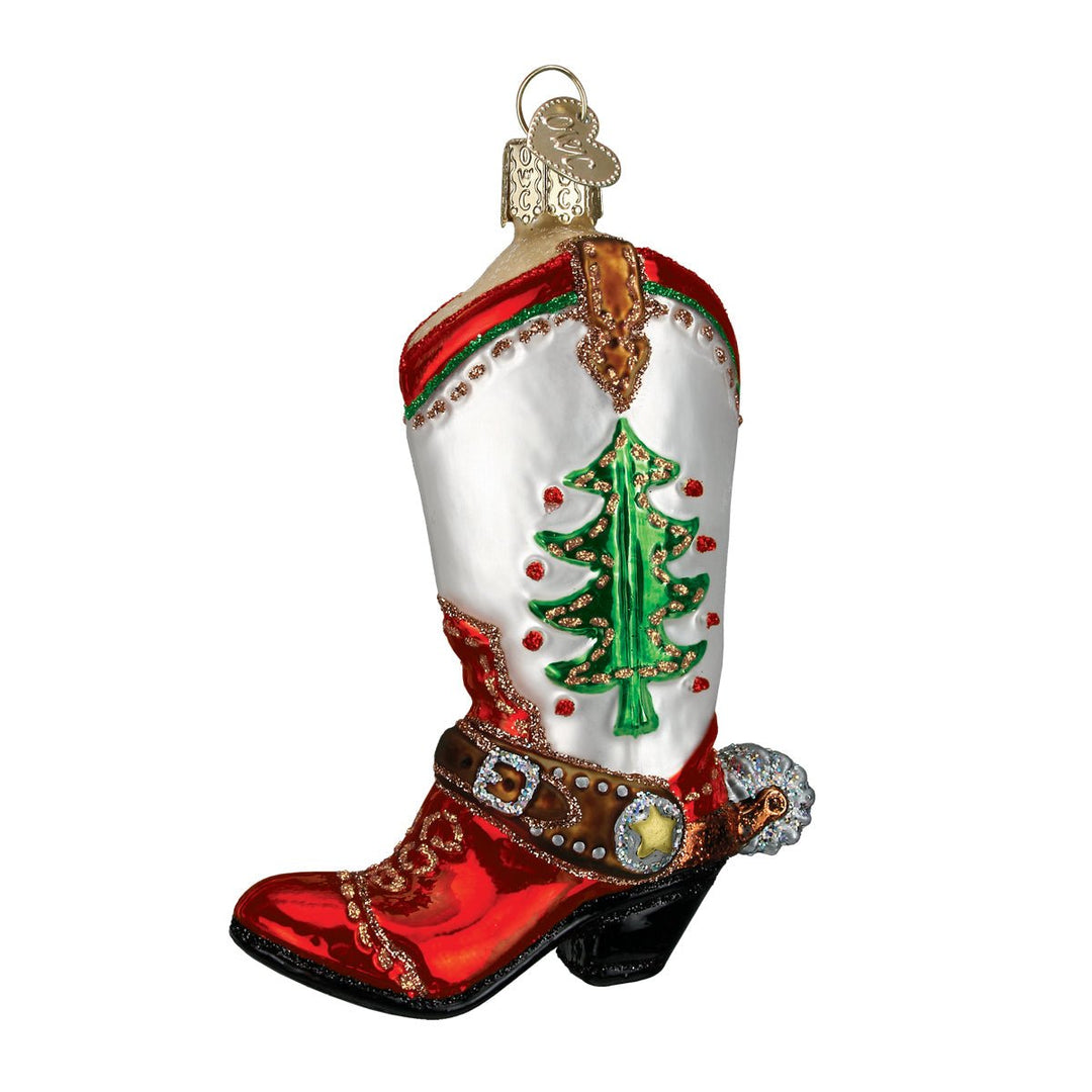 White cowboy boot ornament with a green Christmas tree, red trim, red foot, and spur strap, on white
