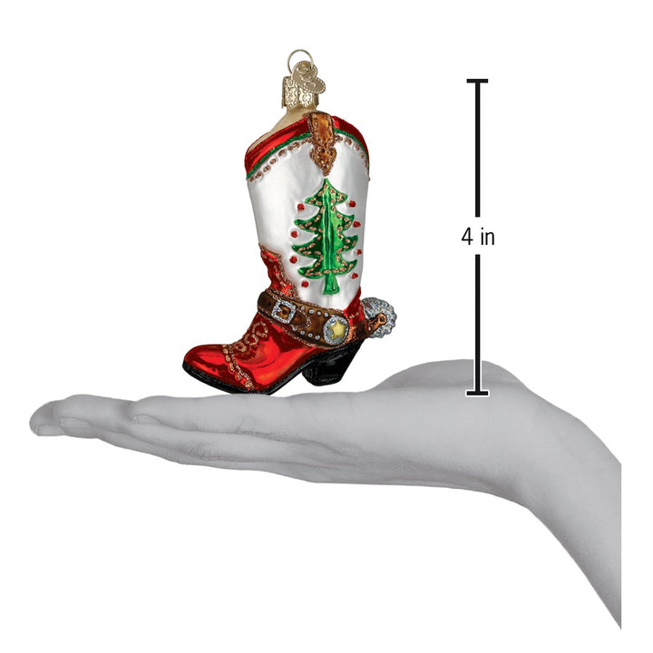 Christmas tree cowboy boot ornament on an open palm beside a 4 inch height marker