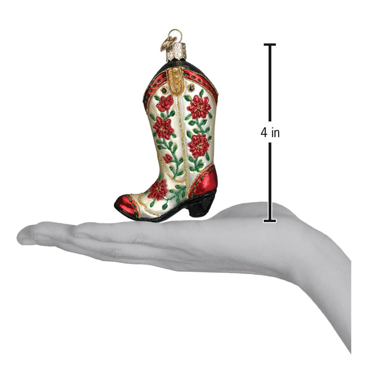 Poinsettia cowgirl boot ornament on an open palm beside a 4 inch height marker