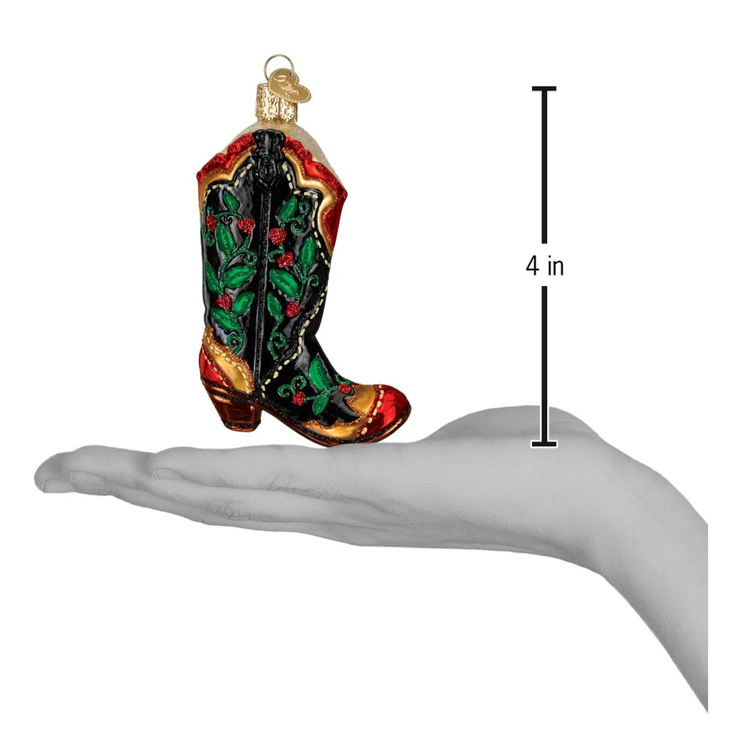 Holly berry cowboy boot ornament on an open palm beside a 4 inch height marker