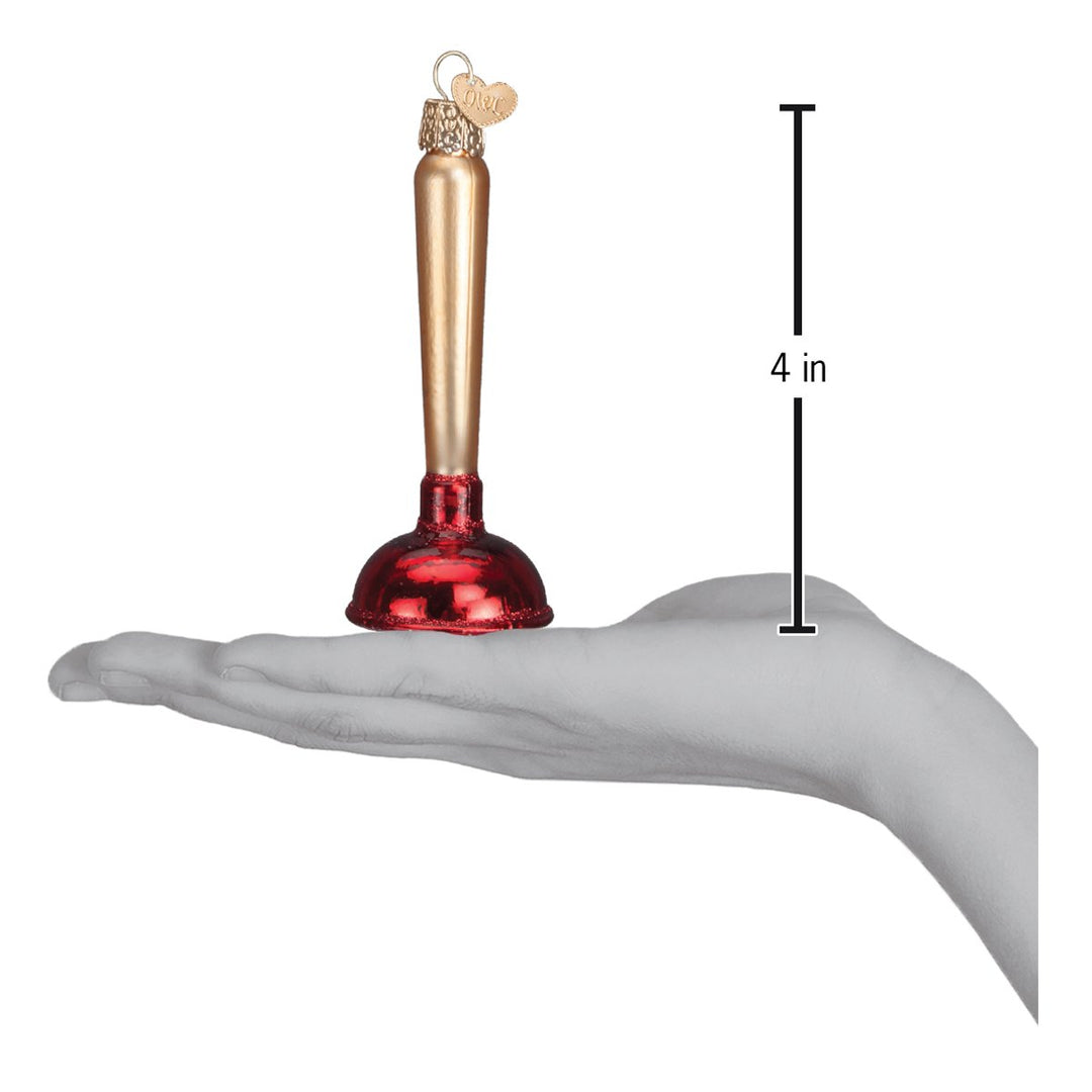 Toilet plunger ornament held above an open palm with a 4 inch height marker for scale