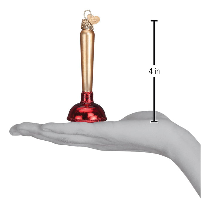 Toilet plunger ornament held above an open palm with a 4 inch height marker for scale