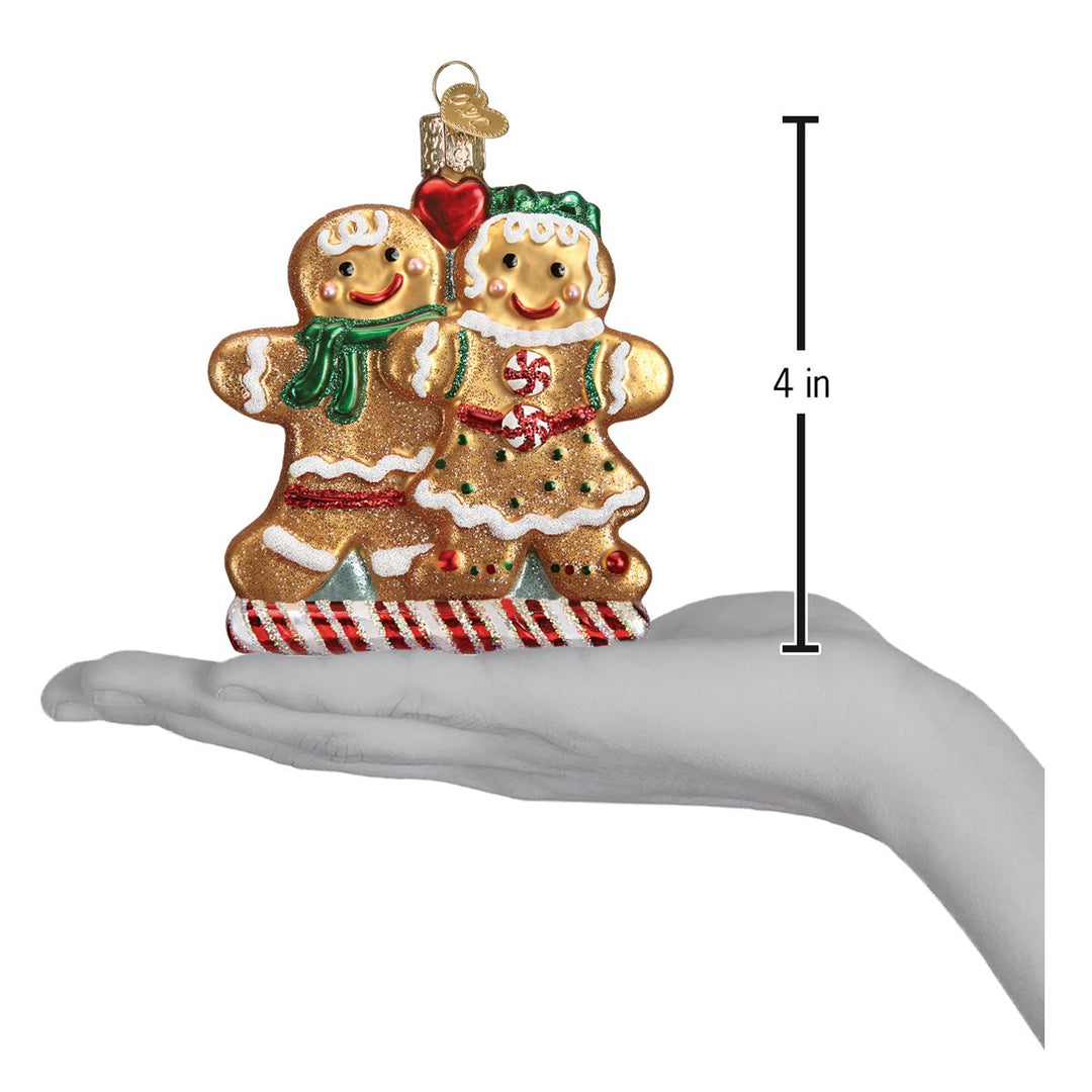 Gingerbread friends ornament on an open palm beside a 4 inch height marker
