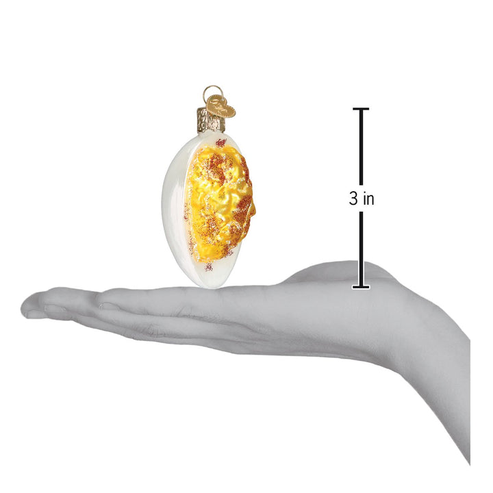 Deviled egg ornament on an open palm beside a 3 inch height marker
