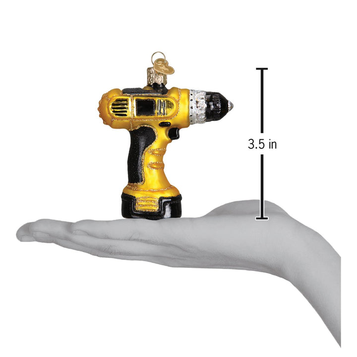 Yellow and black power drill ornament held in an open hand for scale