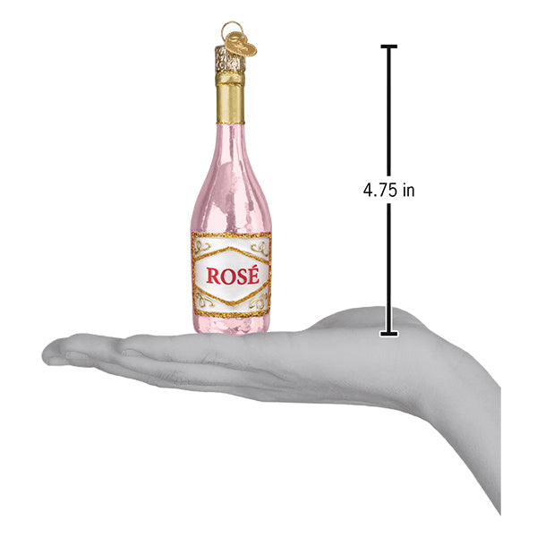 Rosé wine bottle ornament resting on a hand with a 4.75 inch height marker for scale