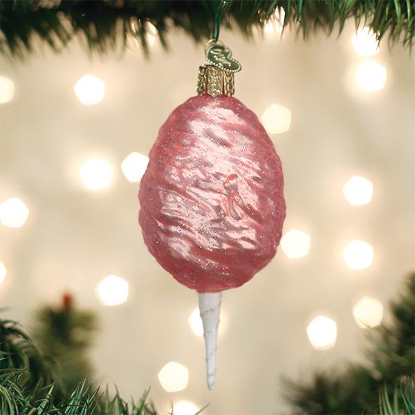 Pink cotton candy ornament hanging on a Christmas tree with glowing bokeh lights