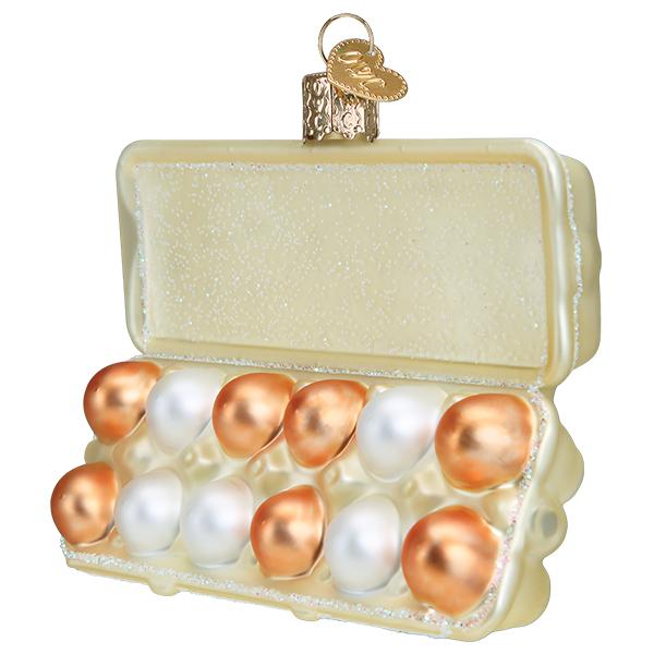 Angled view of the egg carton ornament with brown and white eggs in the open tray, on white