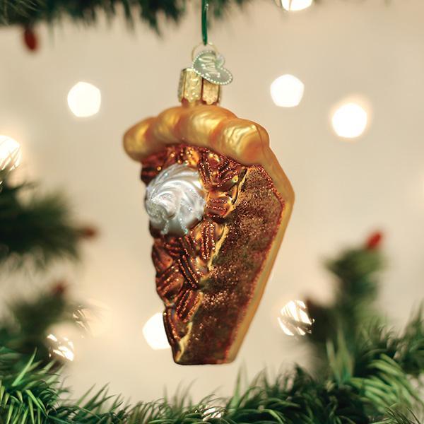 Pecan pie slice glass ornament hanging on a Christmas tree with soft lights
