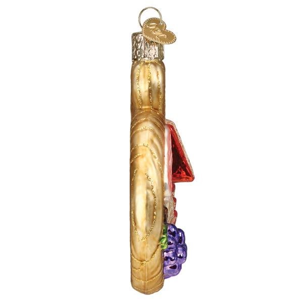 Charcuterie board ornament in profile, showing the slim golden board and raised toppings