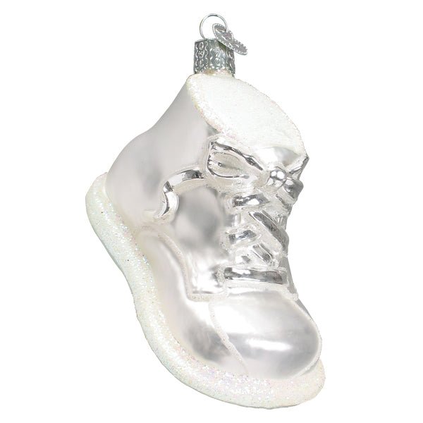 Pearly white baby shoe ornament with white laces and a glittered sole on a white background, three-quarter view