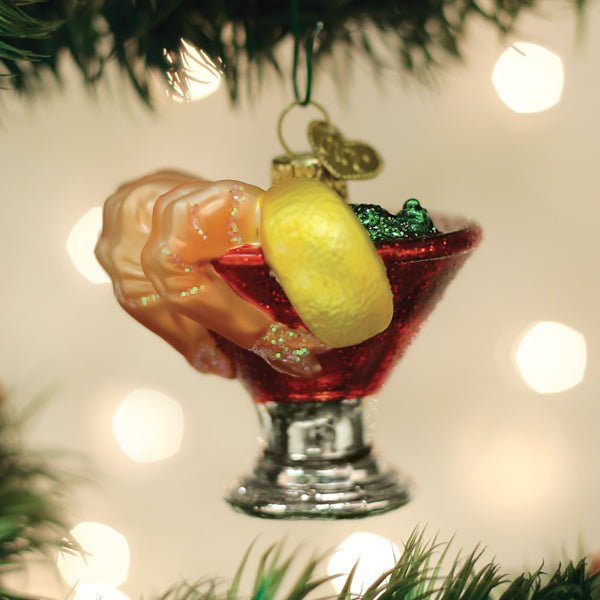 Shrimp cocktail glass ornament hanging on a Christmas tree with bokeh lights for a seafood lover
