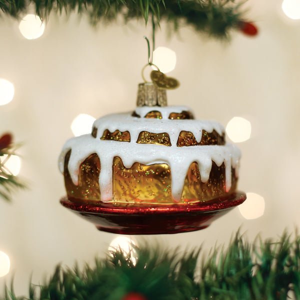 Cinnamon roll glass ornament hanging on a Christmas tree with warm bokeh lights for Christmas morning