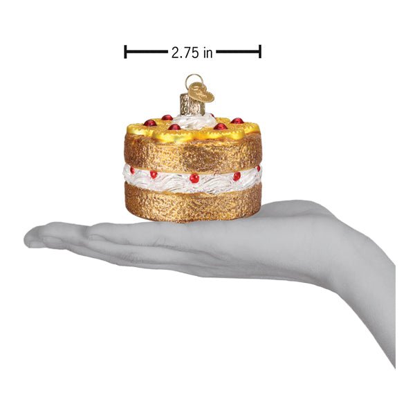Pineapple upside down cake ornament on an open palm beside a 2.75 inch width marker