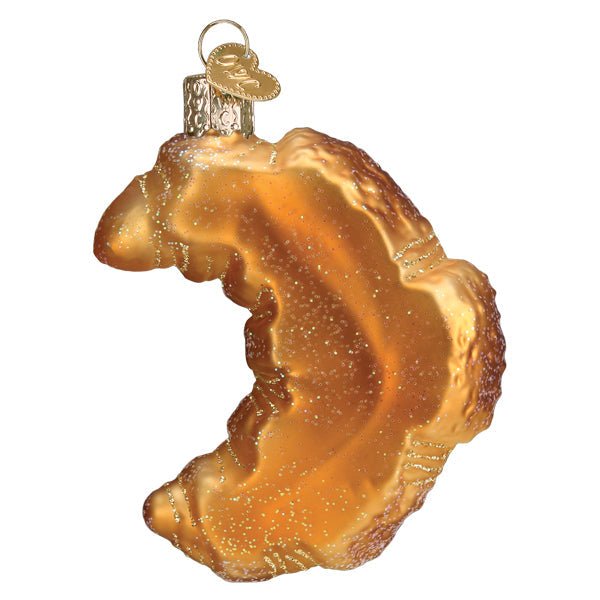 Back of the croissant ornament showing a smooth golden underside with glitter