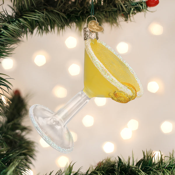 Lemon drop martini glass ornament hanging on a lit Christmas tree