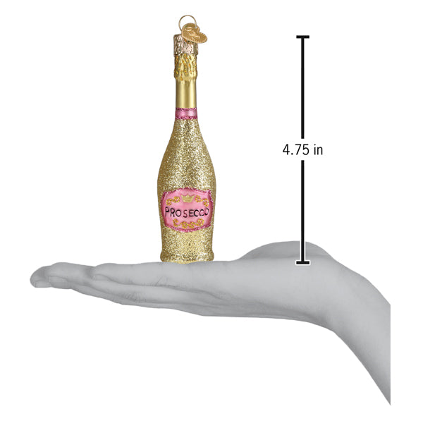 Gold and pink prosecco bottle ornament held in an open hand for scale