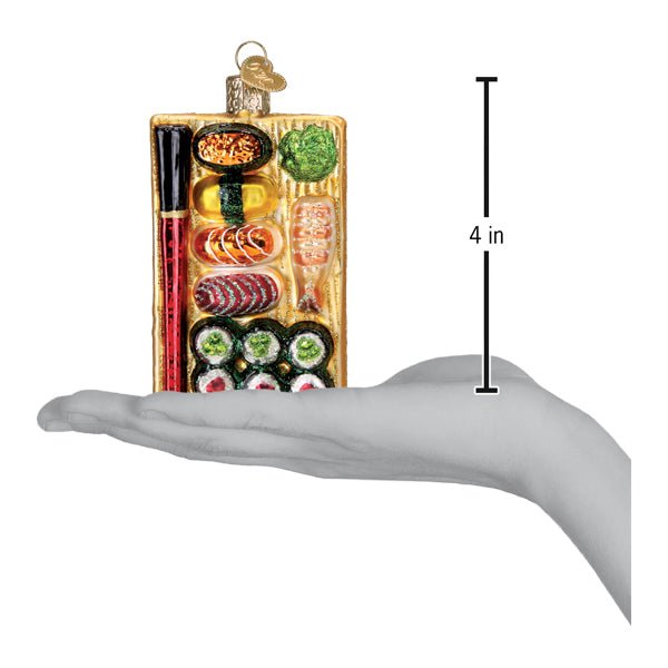 Sushi platter ornament resting on an open hand with a 4 inch scale marker beside it
