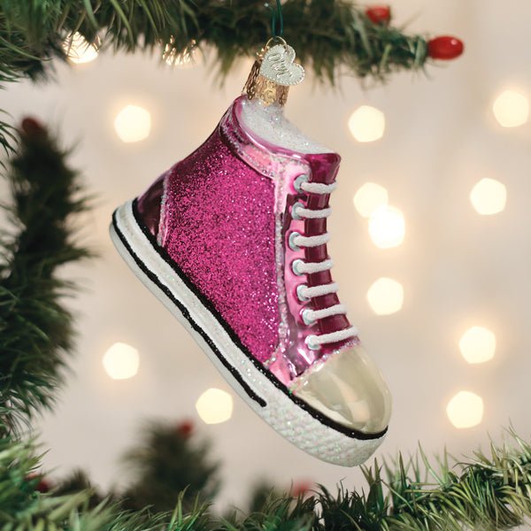 Pink sneaker ornament hanging on a Christmas tree with warm bokeh lights, a gift for sneaker lovers