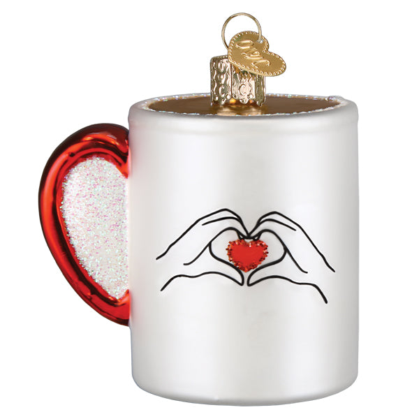 Back of the white mug ornament with a drawing of hands forming a red heart, on white