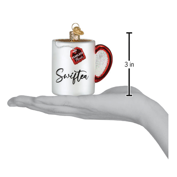 Swiftea mug ornament on an open palm beside a 3 inch height marker