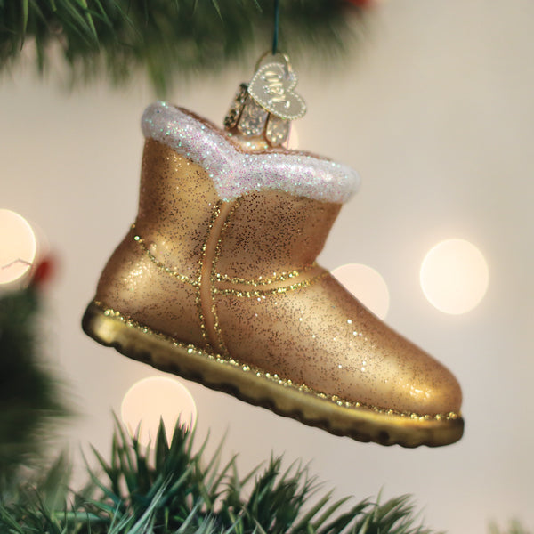 Sheepskin boot ornament hanging on a lit Christmas tree with warm bokeh lights