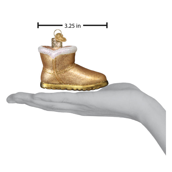 Sheepskin boot ornament on an open palm beside a 3.25 inch length marker