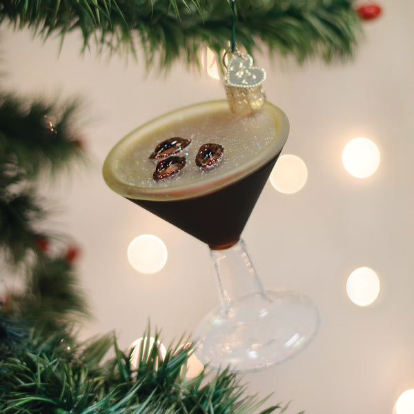 Espresso martini glass ornament hanging on a lit Christmas tree
