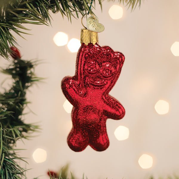 Glittery red SOUR PATCH KID ornament hanging on a lit Christmas tree with warm bokeh lights