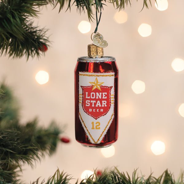 Red Lone Star Beer can ornament hanging on a lit Christmas tree with warm bokeh lights