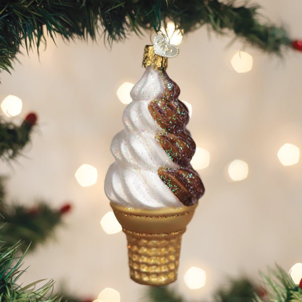 Chocolate swirl soft serve ornament hanging on a Christmas tree with warm twinkle lights