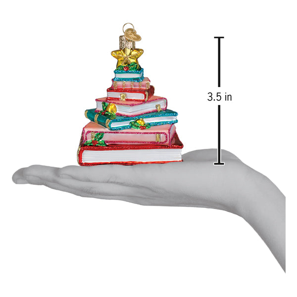 Book club tree ornament on an open palm beside a 3.5 inch height marker