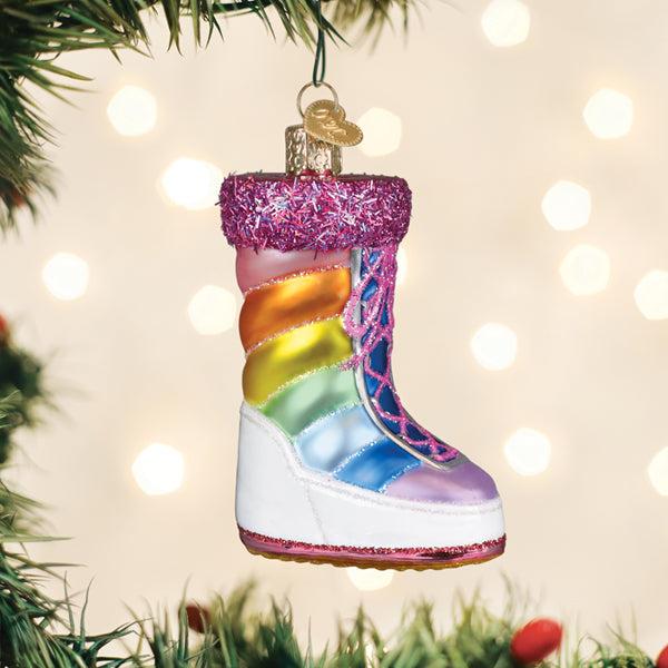 Rainbow snow boot glass ornament hanging on a lit Christmas tree