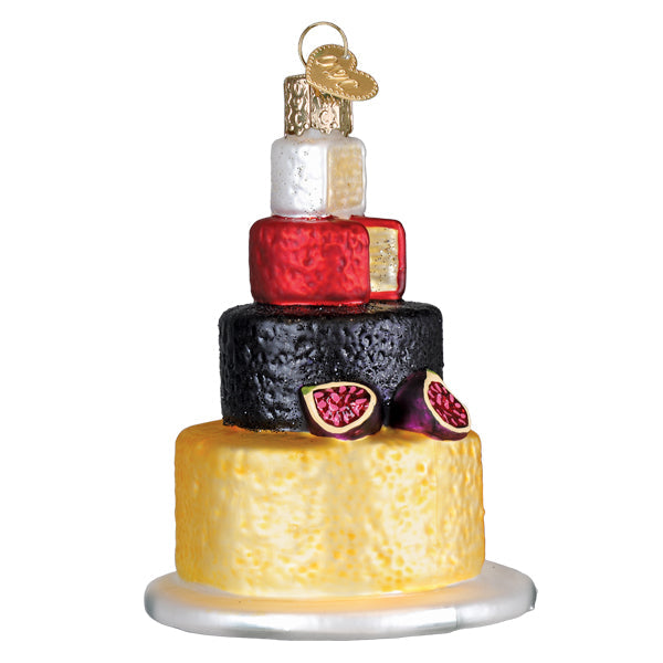 Back of the cheese tower ornament with sliced figs on the black wheel and a yellow cheese base