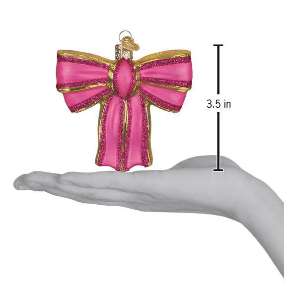 Pink bow ornament held above an open palm with a 3.5 inch height marker for scale
