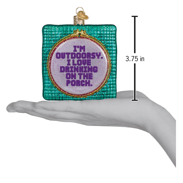 I'm Outdoorsy ornament on an open palm beside a 3.75 inch height marker