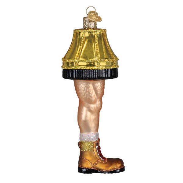 Man leg lamp ornament with a fringed gold shade, white sock, and brown work boot, on white