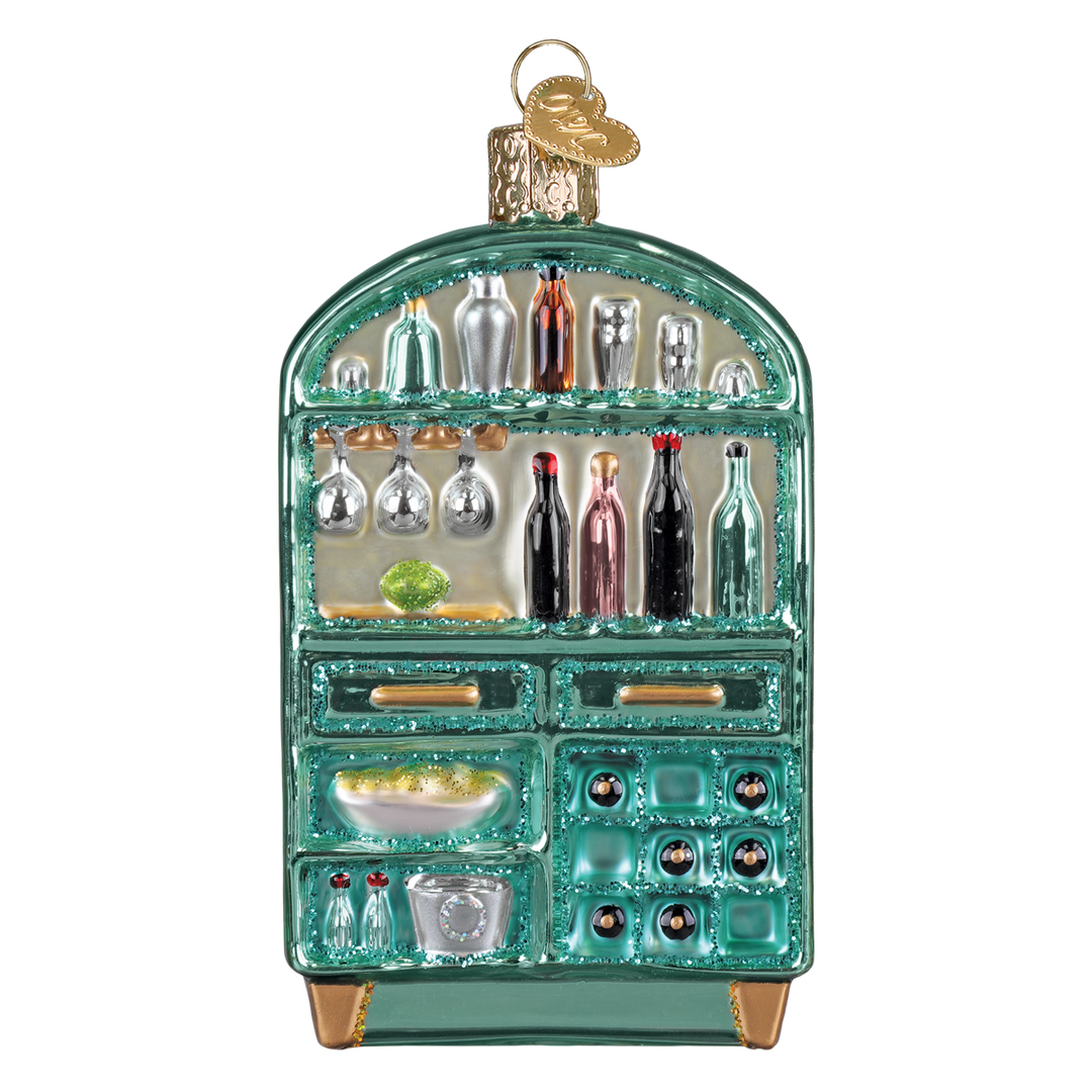 Teal glass bar cabinet Christmas ornament with painted liquor bottles and stemware on its shelves, front view on white